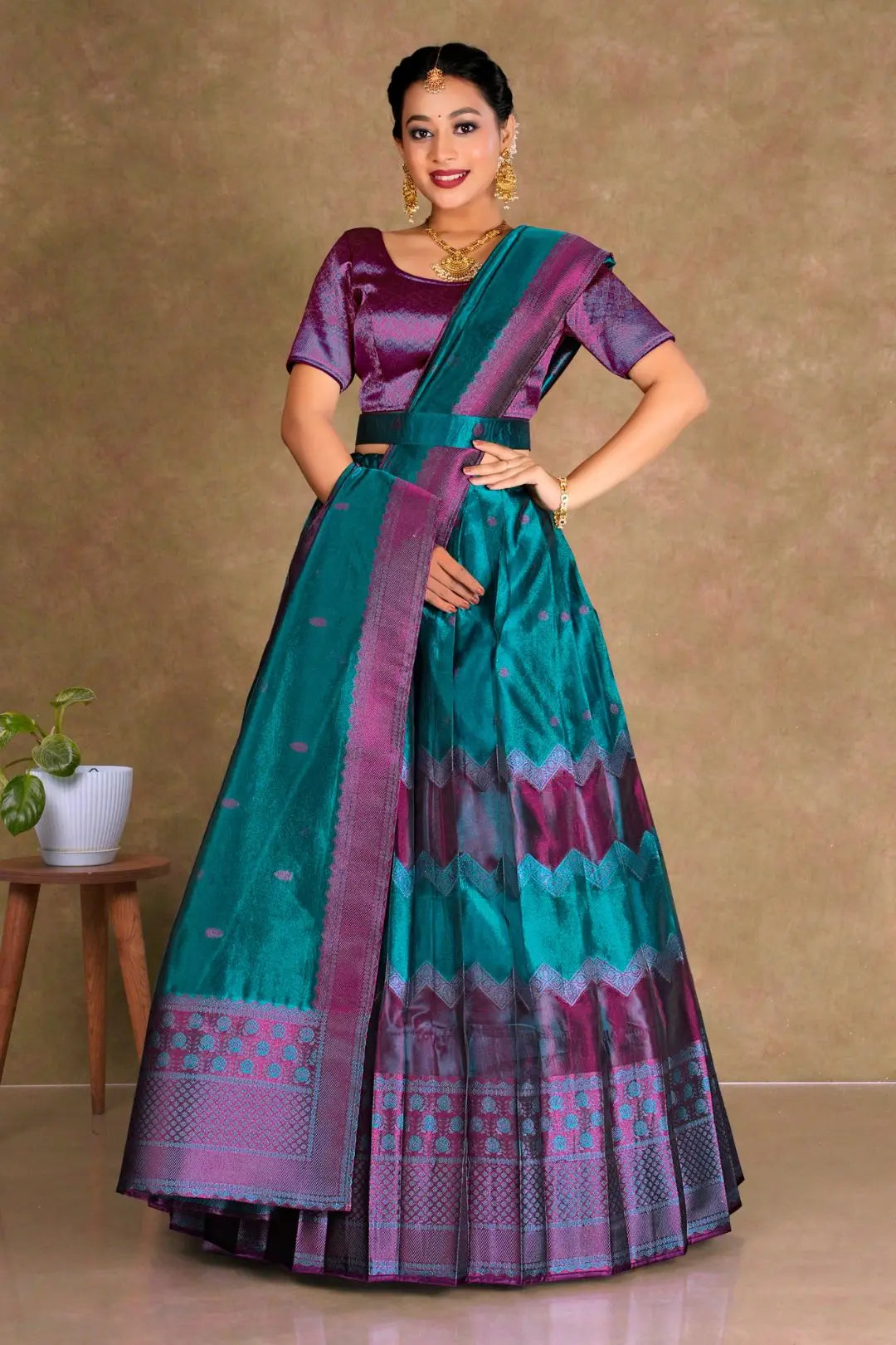 Woman wearing a traditional teal and purple lehenga with a matching blouse