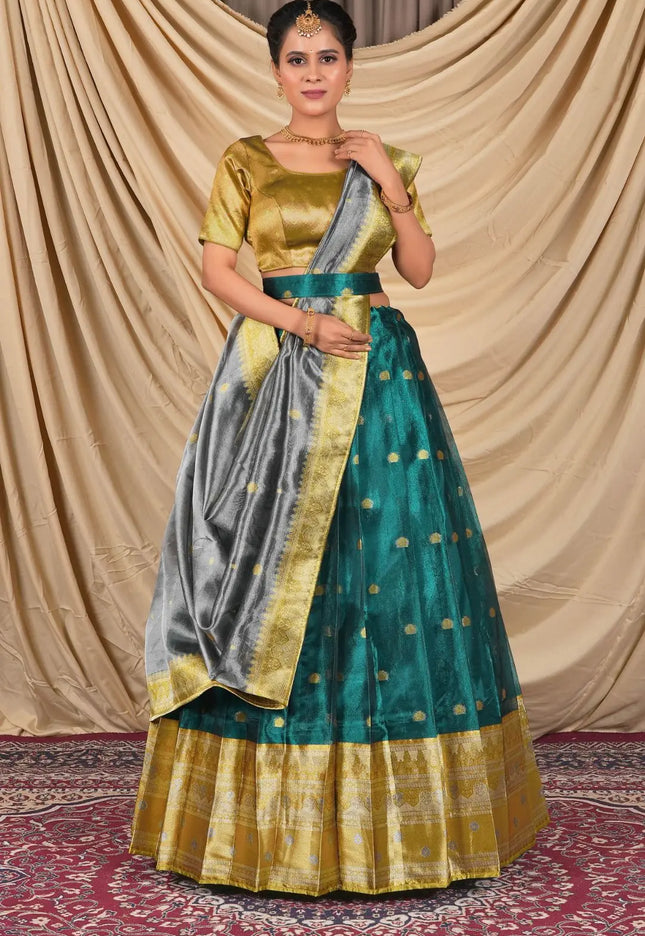 Woman wearing a traditional green and gold lehenga choli with dupatta