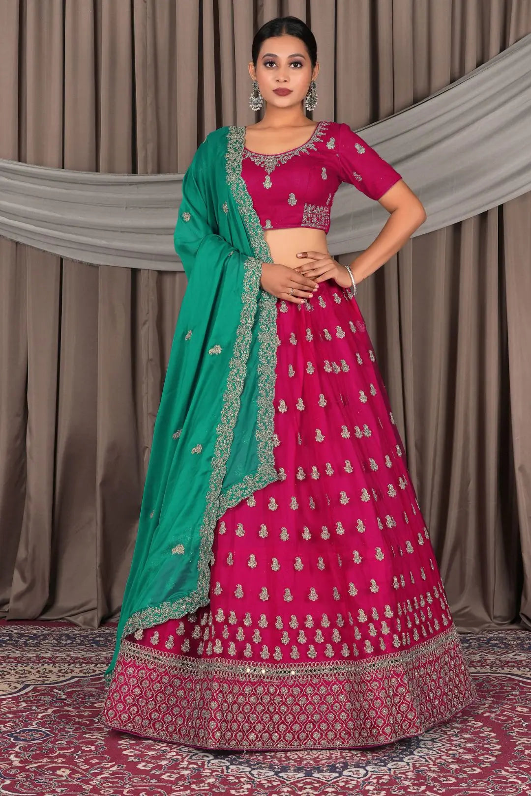 Woman wearing a pink traditional outfit with a green dupatta