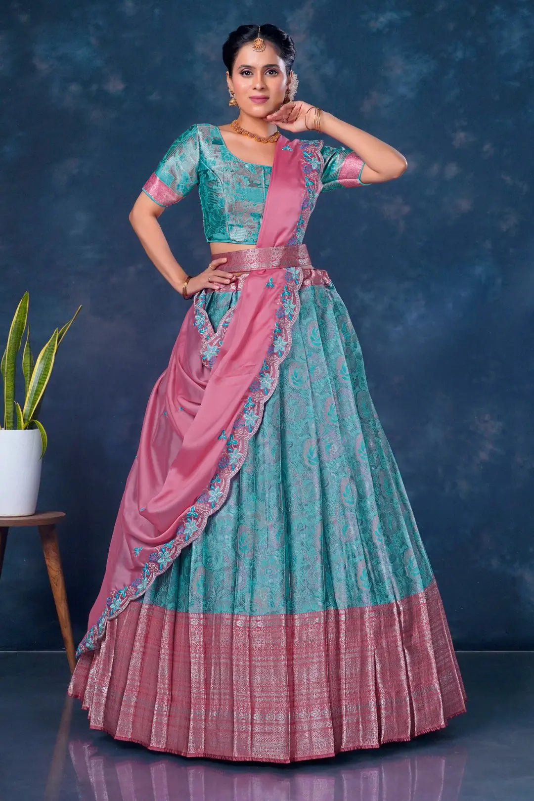 Woman wearing a traditional sea green and pink lehenga