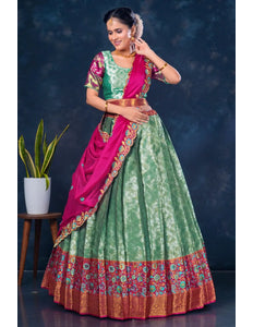 Woman wearing a green and pink traditional lehenga choli with dupatta