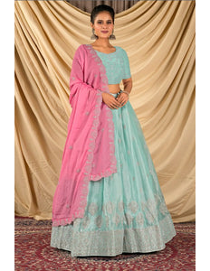Woman wearing a light blue and pink traditional lehenga choli with dupatta