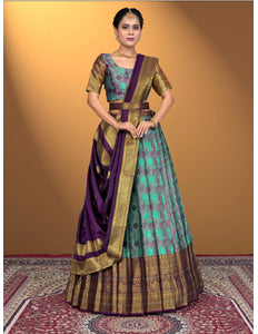 Woman wearing a traditional outfit with a purple and sea green lehenga choli