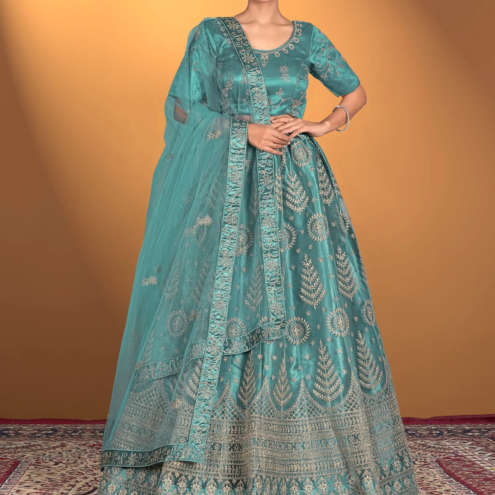 Woman wearing a teal embroidered traditional outfit