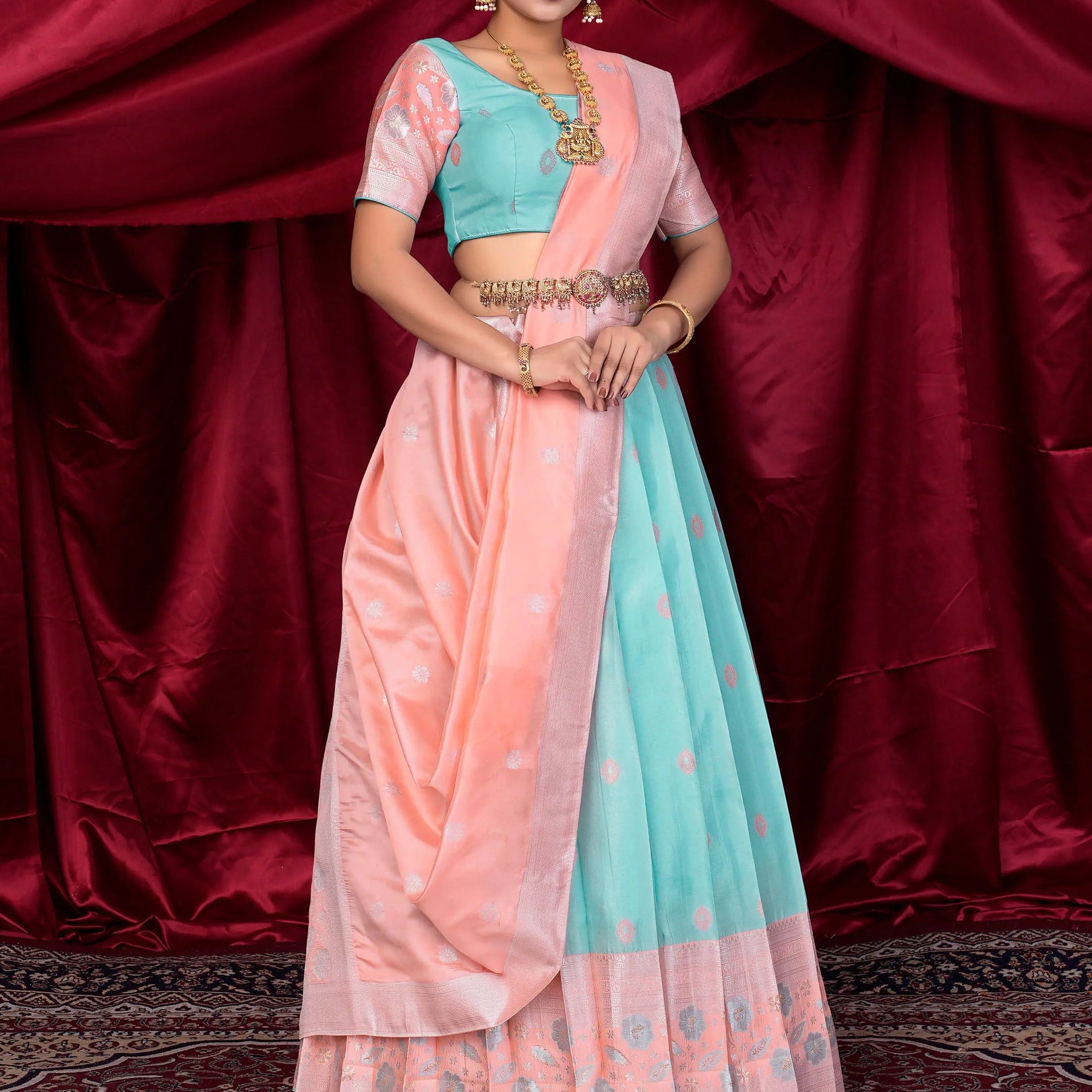 Woman wearing a traditional outfit with a pink and light blue lehenga choli