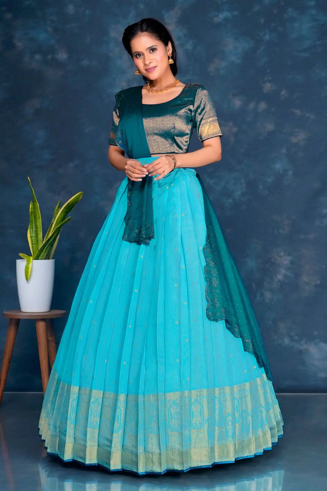 Woman wearing a sky blue and green traditional lehenga choli with dupatta