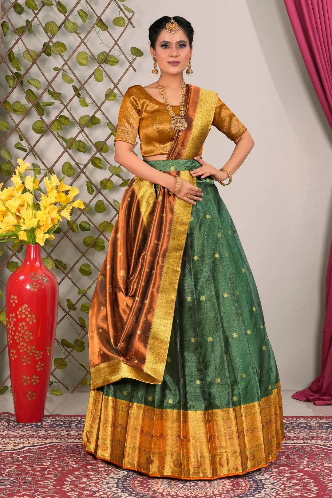 Woman wearing a traditional green and gold lehenga choli with dupatta