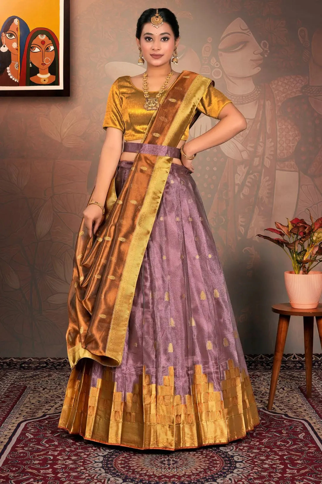 Woman wearing a traditional gold and purple lehenga choli and dupatta