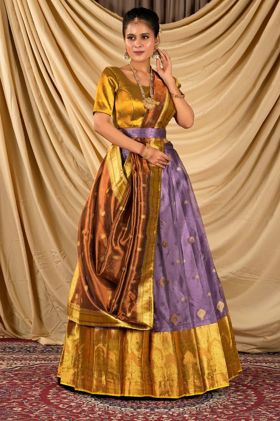 Woman wearing a traditional gold and purple lehenga choli with dupatta