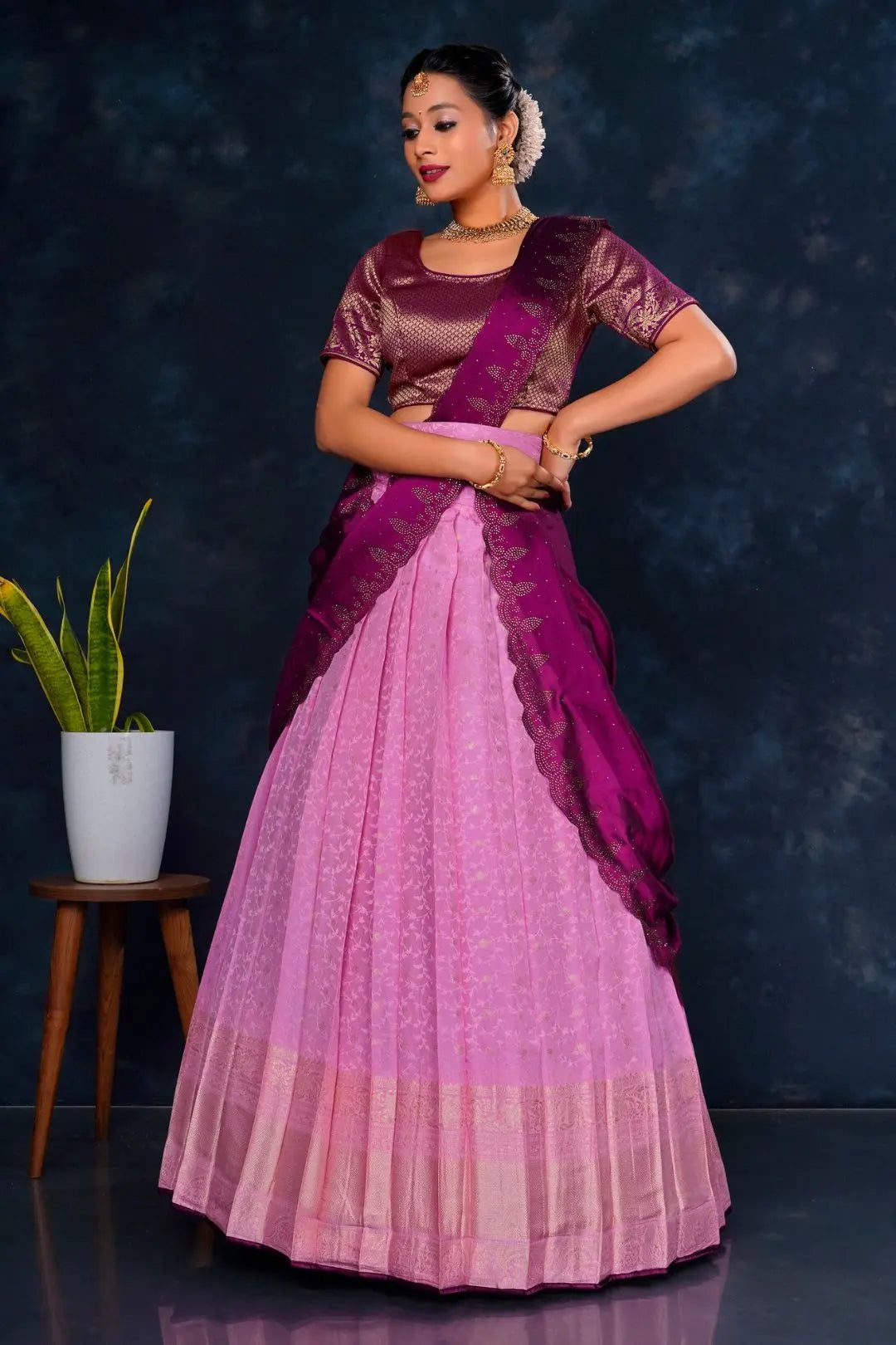 Woman wearing a pink and purple lehenga choli with dupatta