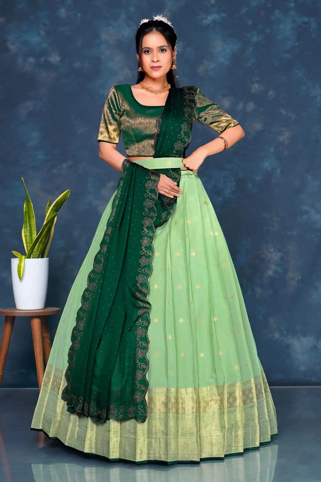 Woman wearing a green and light green traditional lehenga choli with dupatta