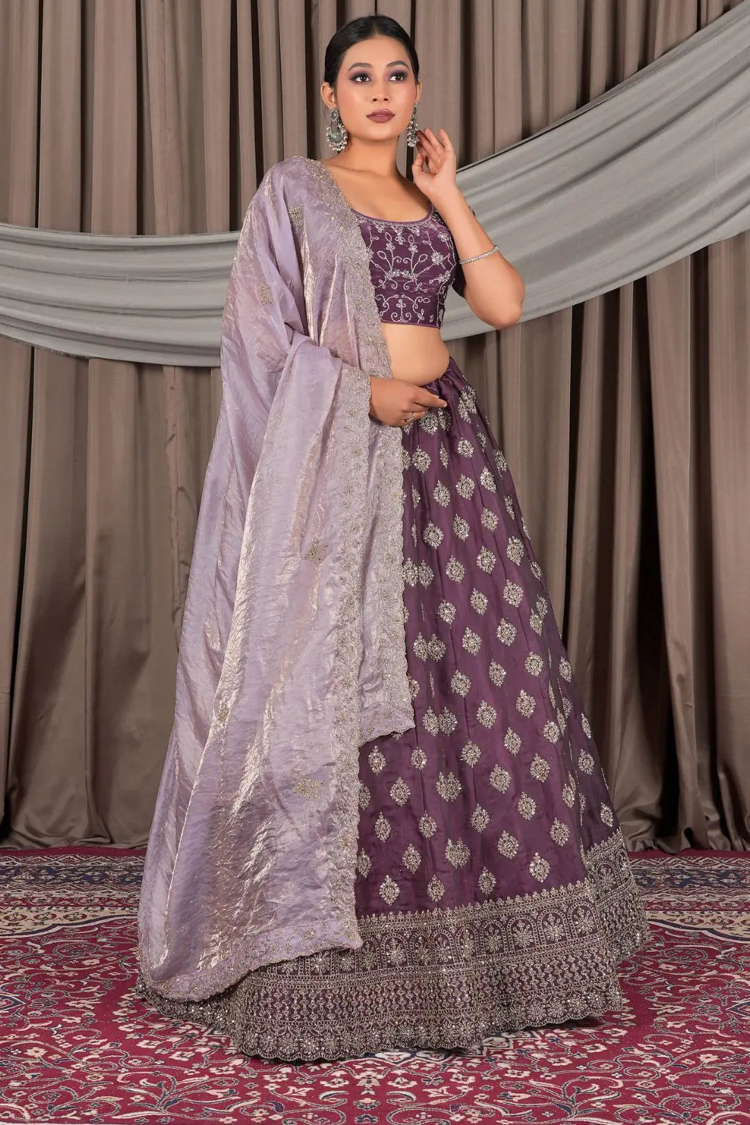 Woman wearing a traditional purple and gray lehenga with a matching dupatta
