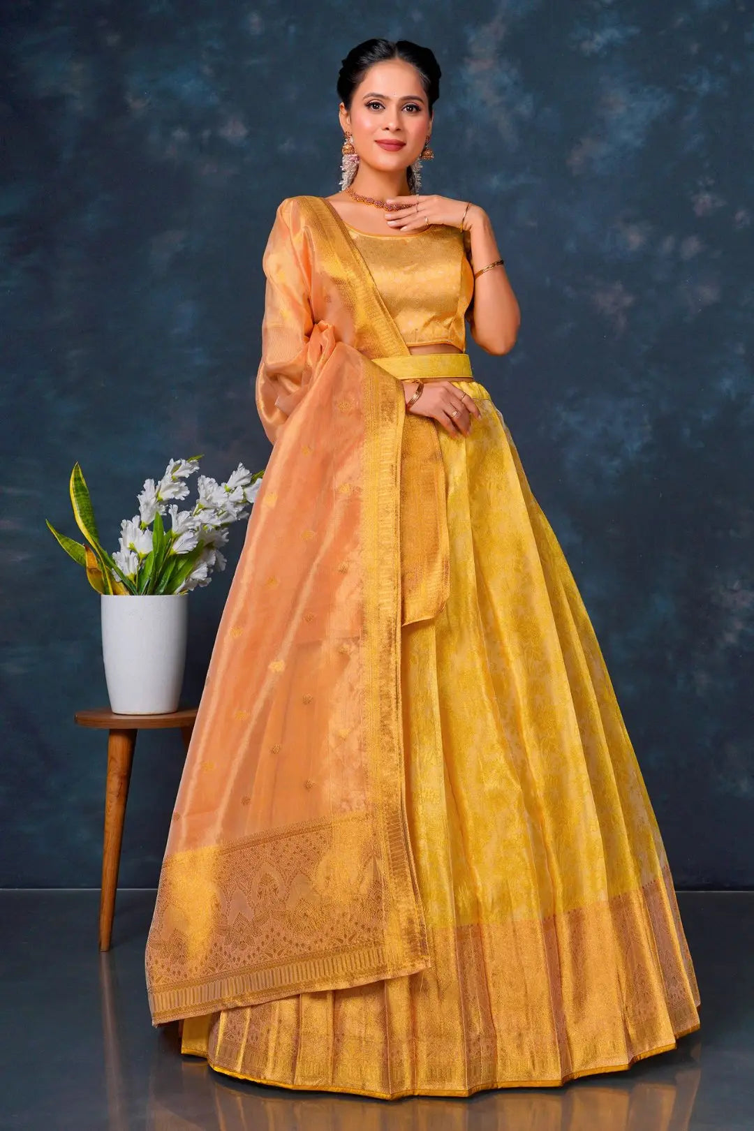Woman in a yellow and orange lehenga choli with dupatta