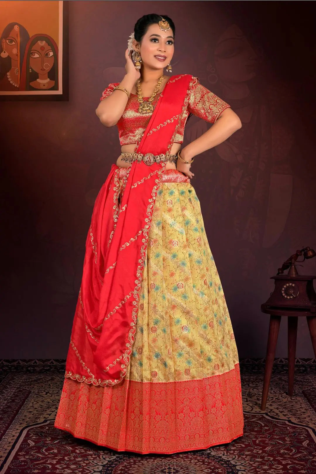 Woman wearing a red and yellow traditional outfit with intricate patterns.