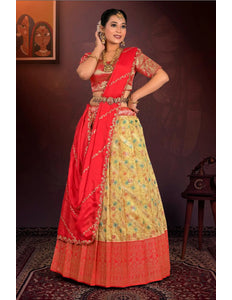 Woman wearing a red and yellow traditional outfit with intricate patterns.