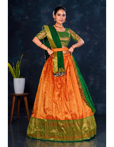 Woman wearing an orange and green traditional lehenga choli with dupatta