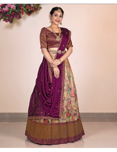 Woman wearing a traditional purple and Chiku Lehenga Choli with a floral pattern