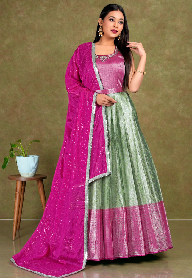 Woman wearing a pink and green traditional outfit with a matching dupatta