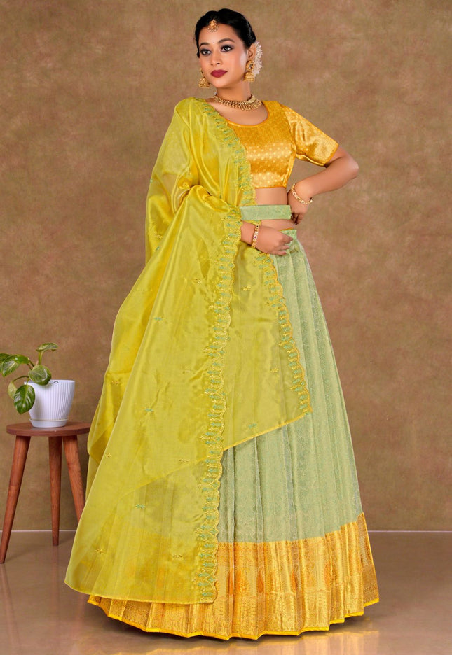 Woman wearing a yellow and green traditional lehenga choli with dupatta