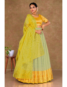 Woman wearing a yellow and green traditional lehenga choli with dupatta