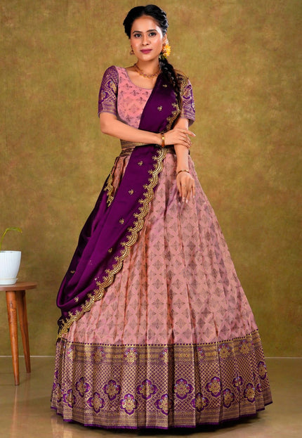 Woman wearing a traditional pink and purple lehenga with a gold border