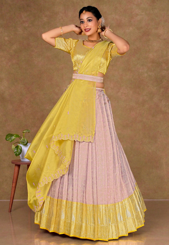 Woman wearing a yellow and pink traditional lehenga choli with dupatta
