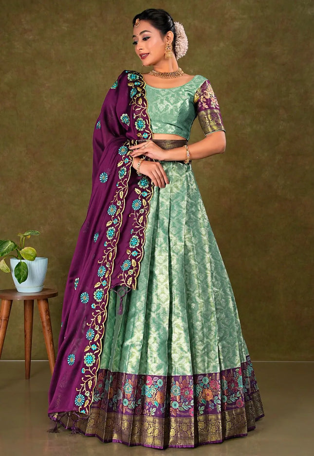 Woman wearing a green and purple traditional outfit with a matching lehenga and choli