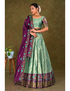 Woman wearing a green and purple traditional outfit with a matching lehenga and choli