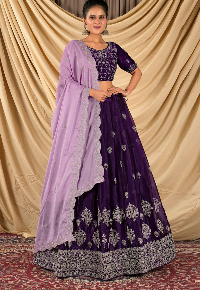 Woman wearing a purple traditional outfit with a light purple dupatta
