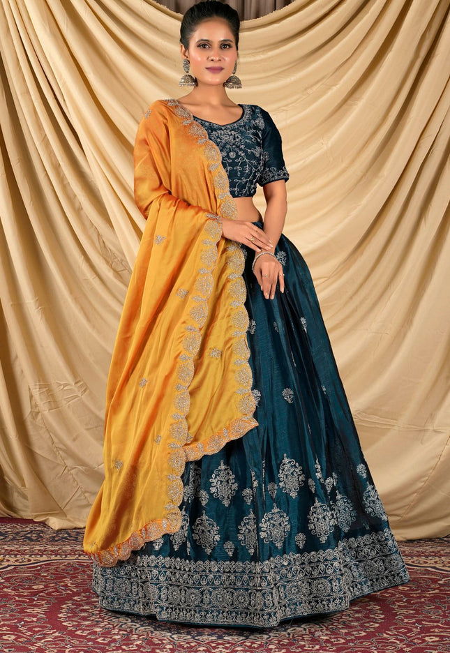 Woman wearing a blue and yellow lehenga choli with dupatta