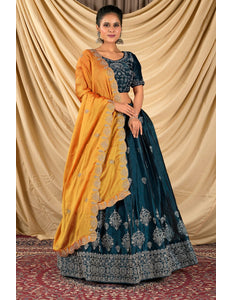 Woman wearing a blue and yellow lehenga choli with dupatta