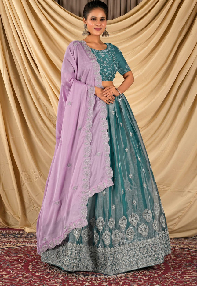 Woman wearing a teal and purple traditional lehenga choli with dupatta