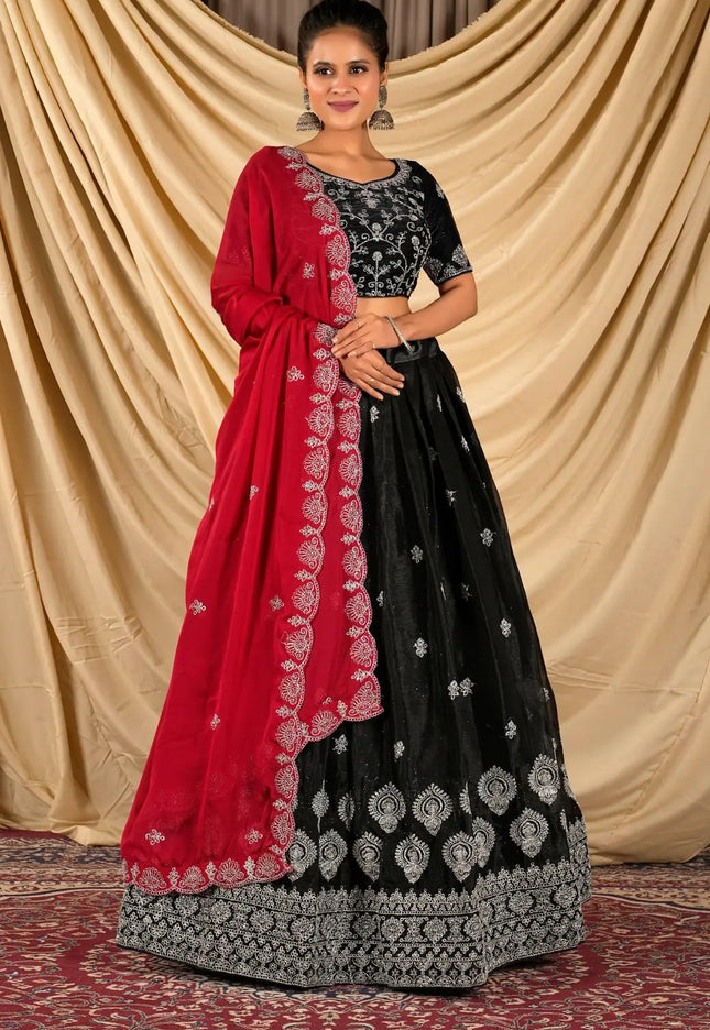 Woman wearing a black and red traditional lehenga choli and dupatta
