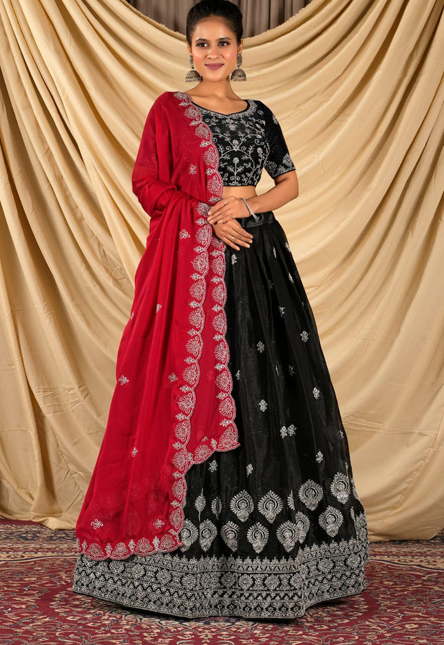 Woman wearing a black and red traditional lehenga choli and dupatta