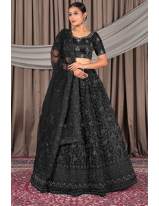 Woman wearing a black embroidered traditional lehenga choli with dupatta