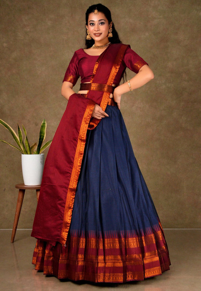 Woman wearing a traditional saree with a maroon blouse and blue skirt