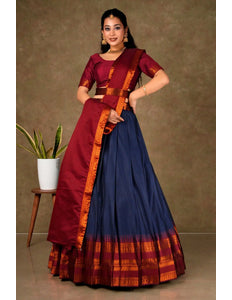 Woman wearing a traditional saree with a maroon blouse and blue skirt