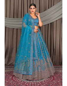 Woman in a blue embroidered traditional outfit standing