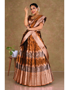 Woman wearing a traditional lehenga with a brown and beige pattern