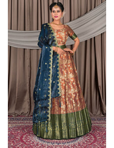 Woman wearing a traditional outfit with a brown and blue lehenga and a patterned blouse