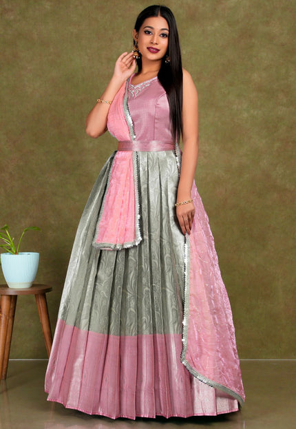 Woman wearing a pink and gray traditional lehenga choli with dupatta