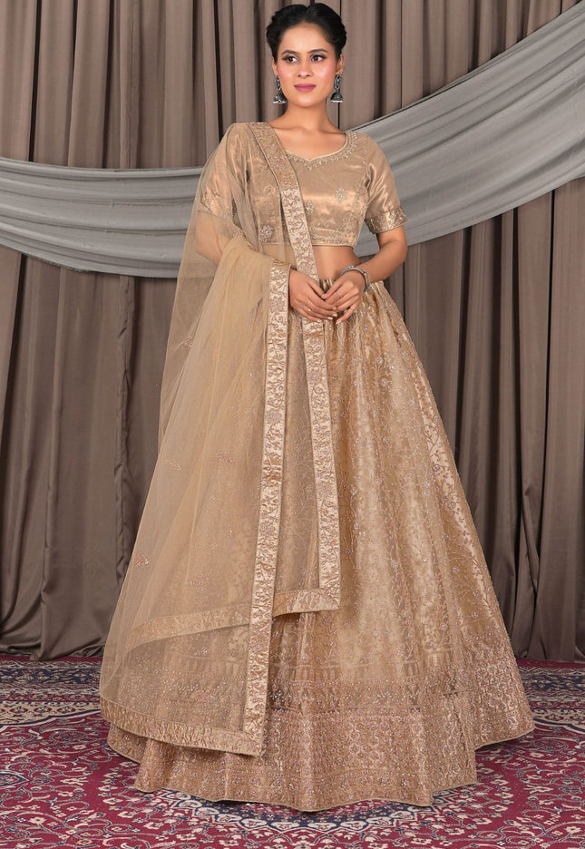 Woman wearing a traditional beige outfit with a dupatta