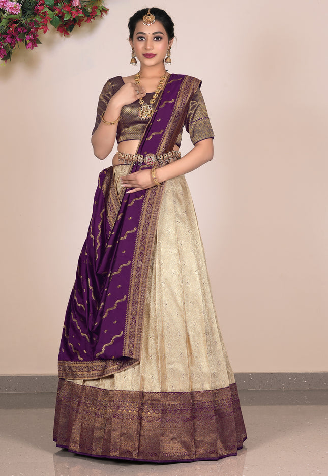 Woman wearing a traditional outfit with a purple and beige lehenga choli