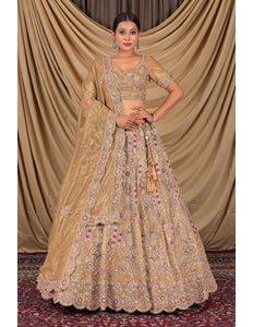 Woman wearing a traditional beige embroidered lehenga