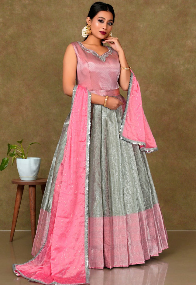 Woman wearing a pink and gray traditional outfit with a matching dupatta