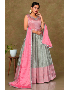 Woman wearing a pink and gray traditional outfit with a matching dupatta