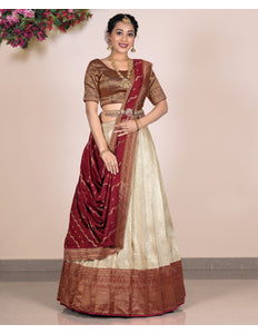 Woman wearing a traditional lehenga with a maroon and beige color scheme 