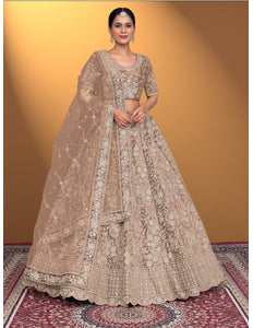 Woman in a traditional beige embroidered lehenga choli with dupatta