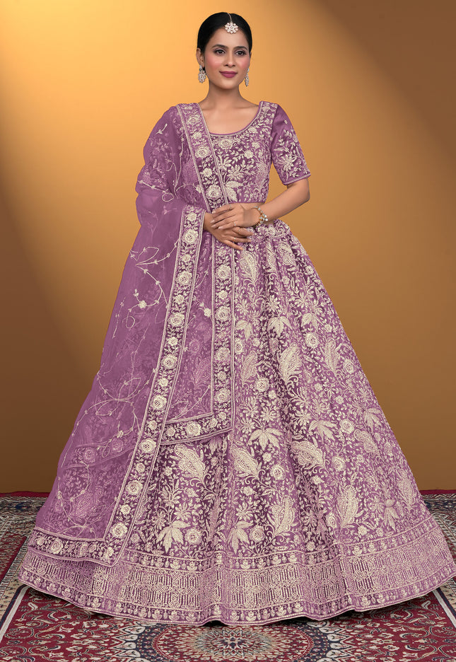 Woman wearing a purple embroidered traditional outfit on a patterned