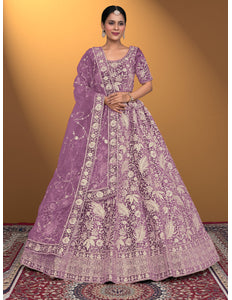 Woman wearing a purple embroidered traditional outfit on a patterned